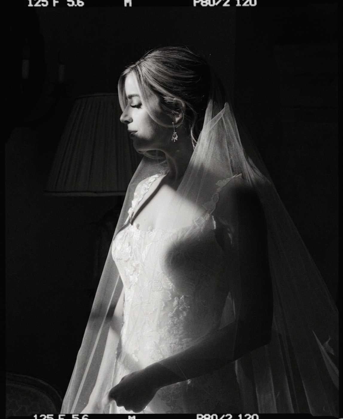 A bridal portrait matched to a black-and-white medium-format look. The veil keeps its translucence and the gown its detail, while the grain and frame edge come from the reference, not the camera.