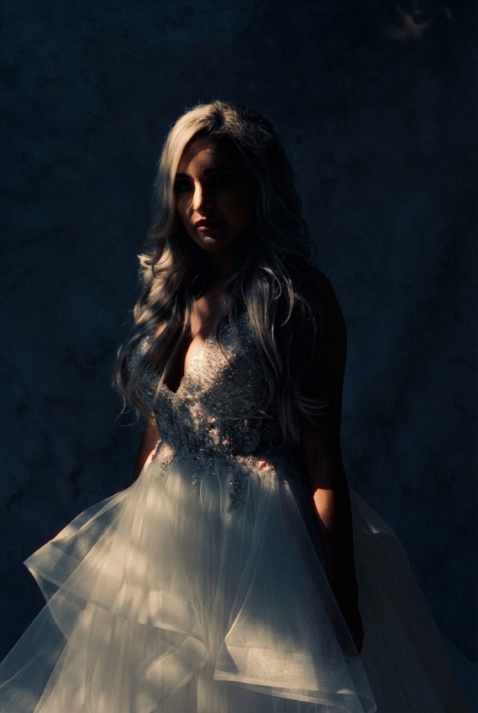 A bride against deep teal, lit by one tungsten edge. Restraint as drama.